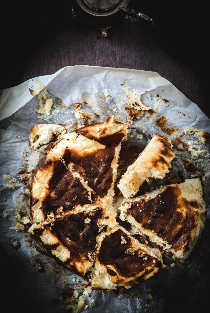Lemon Burnt Basque Cheesecake Recipe with one piece tilted sideways on parchment paper