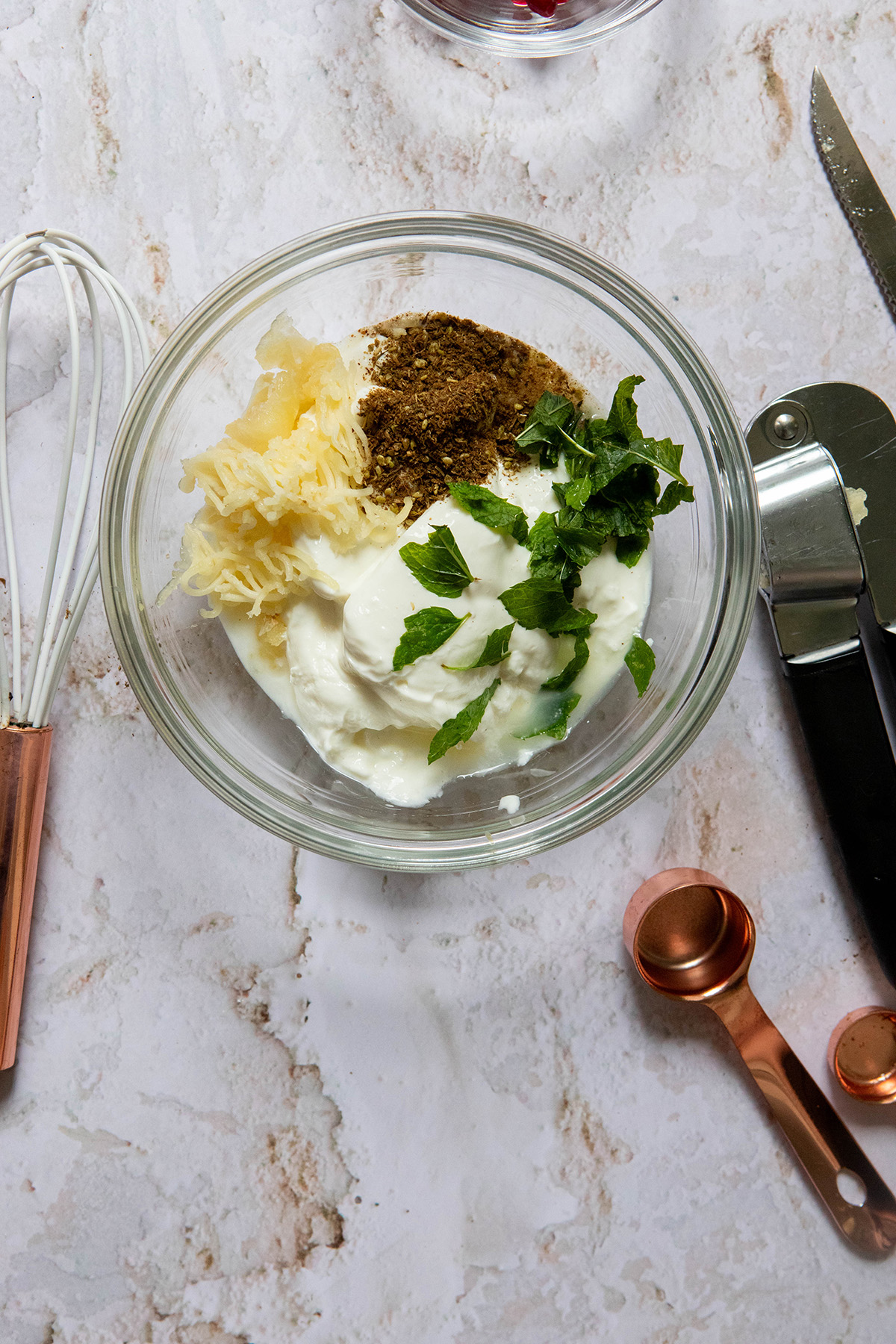 glass bowl with ingredients for garlic sauce