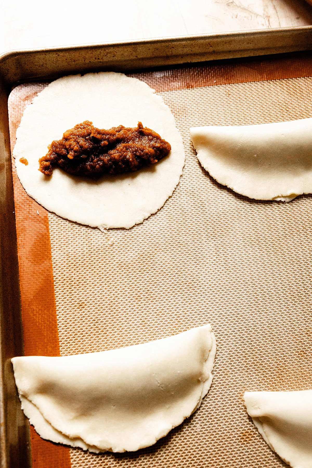 one pasty open with filling while others are folded over pumpkin pasties 