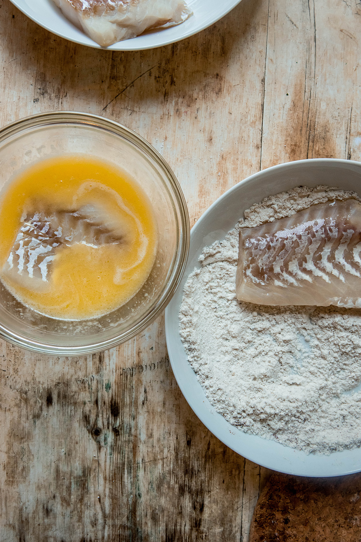 cod filet dunked in butter mixture and flour