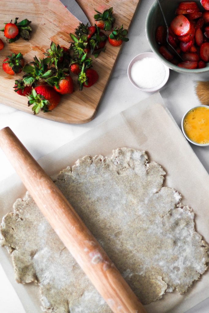 Galette being rolled out with strawberries.