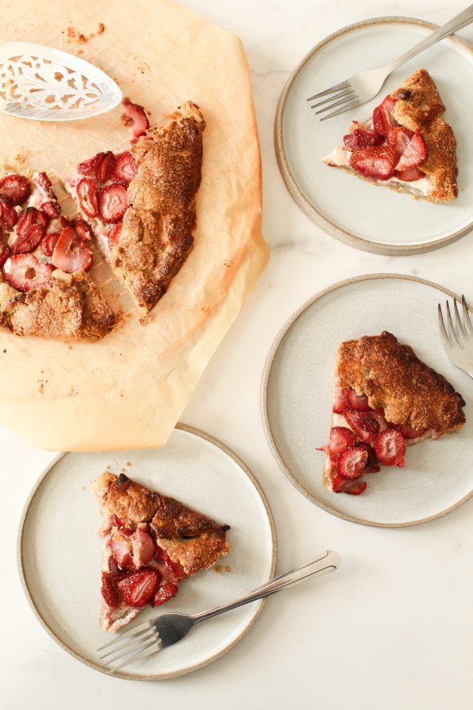 Sliced pieces of galette on three plates and a few on a tray.