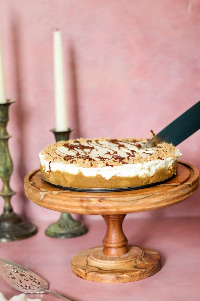 cutting into a heath bar cheesecake