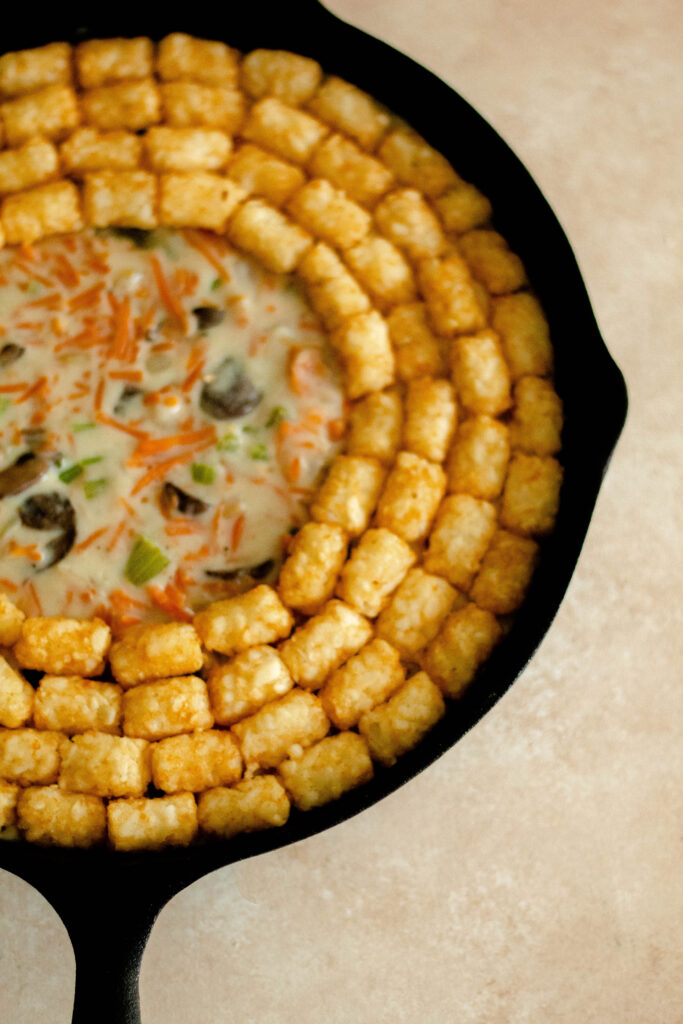 Gluten Free Vegetable Tater Tot Casserole in a cast iron pan.
