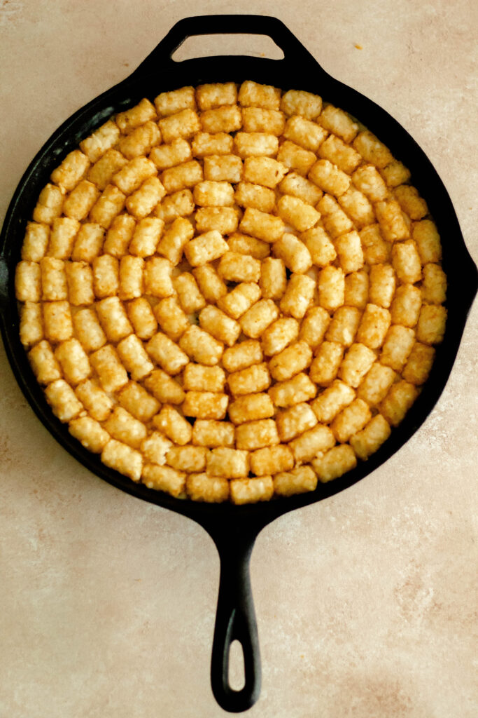 Gluten Free Vegetable Tater Tot Casserole in a cast iron pan.