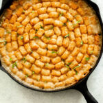 Gluten Free Vegetable Tater Tot Casserole in a cast iron pan.