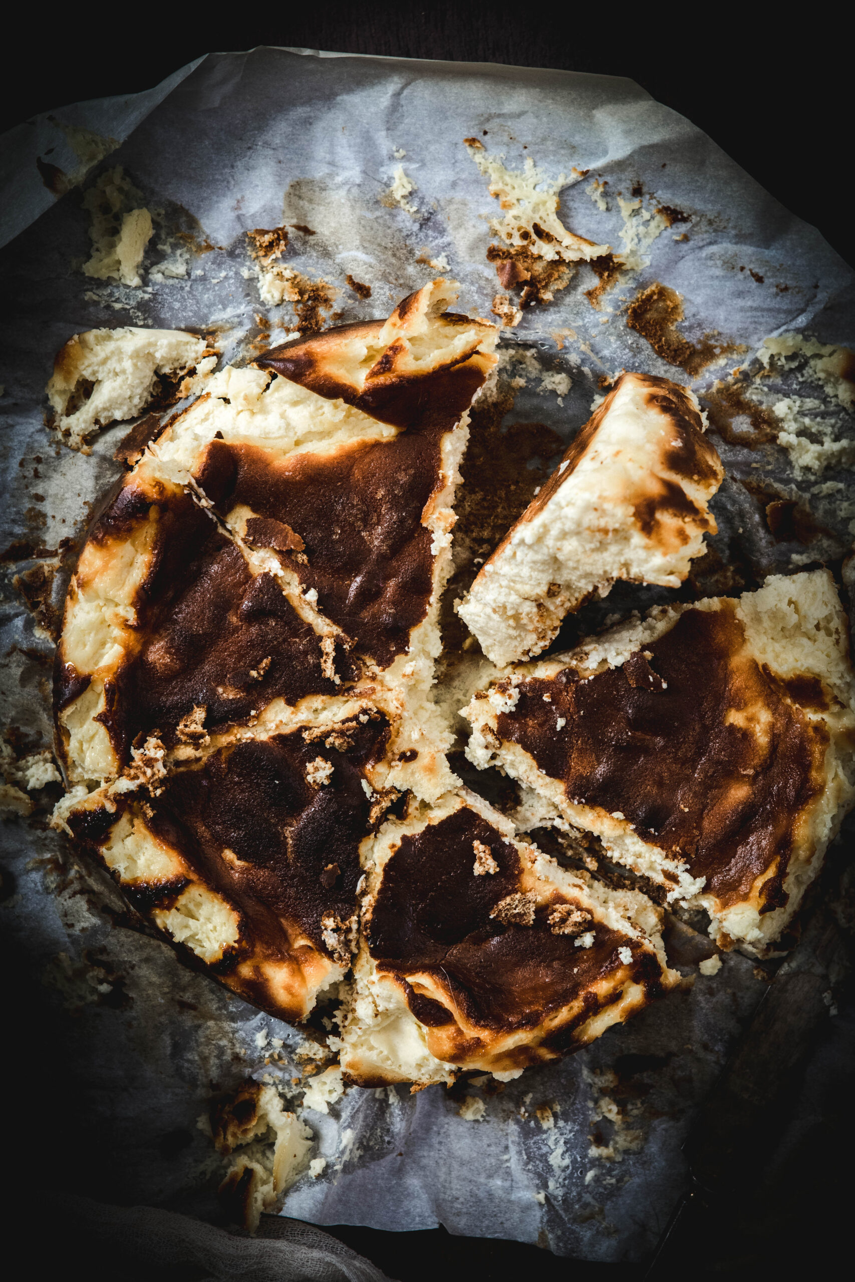 Lemon Burnt Basque Cheesecake Recipe with one piece tilted sideways on parchment paper